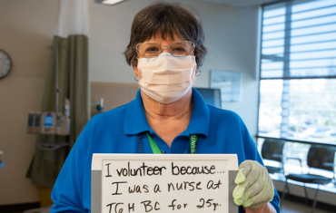 Volunteer holds white board with text 