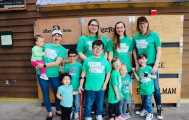 Group of chidren and adults smiles for camera