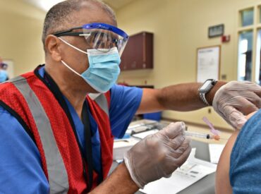 Health care worker vaccinates community member at pop-up clinic