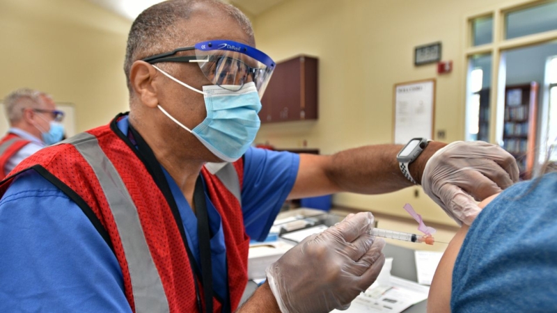 Health care worker vaccinates community member at pop-up clinic