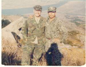 Two men in army uniforms outside