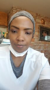 Woman in scrubs smiles for camera