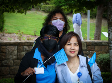 Three women in masks face the camera