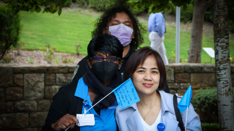 Three women in masks face the camera