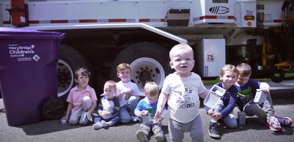 Kids sitting in front of waste connections cart and truck
