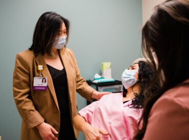 Clinician in mask helps patient